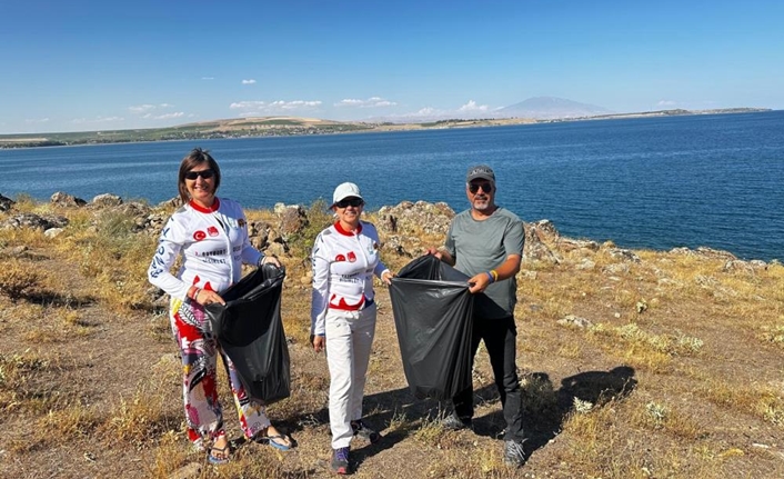 Tatvan sahilinde çöp toplayan Van Gölü Aktivistleri Derneği üyeleri poşetlerle